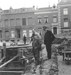 857475 Afbeelding van de opgravingen op het Domplein te Utrecht, met archeoloog A.E. van Giffen, achter hem ...